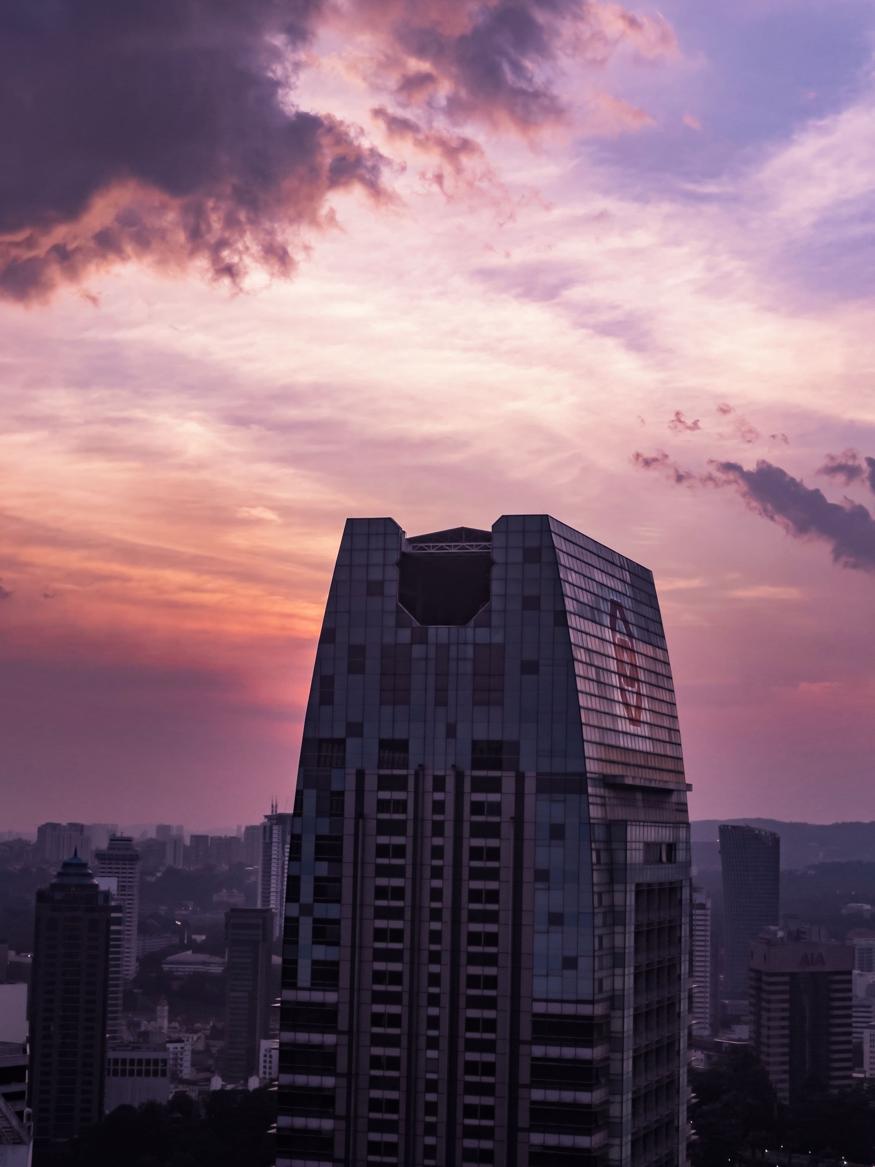A high-rise financial district building beneath a pink and purple evening sky